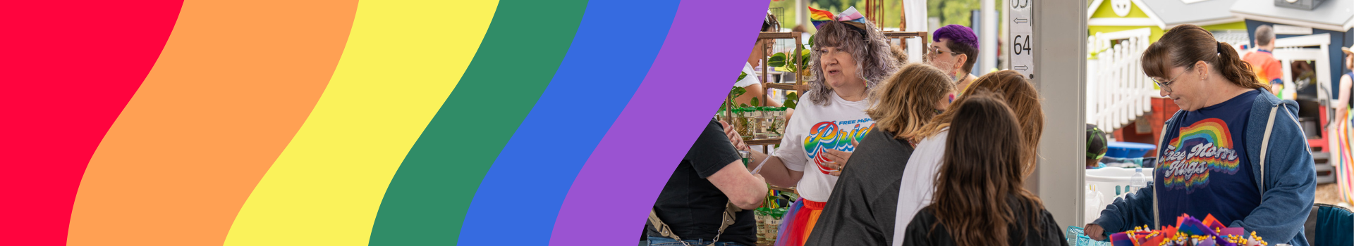 Photo that shows a rainbow graphic with a vendor and shoppers at the Meridian Pride event